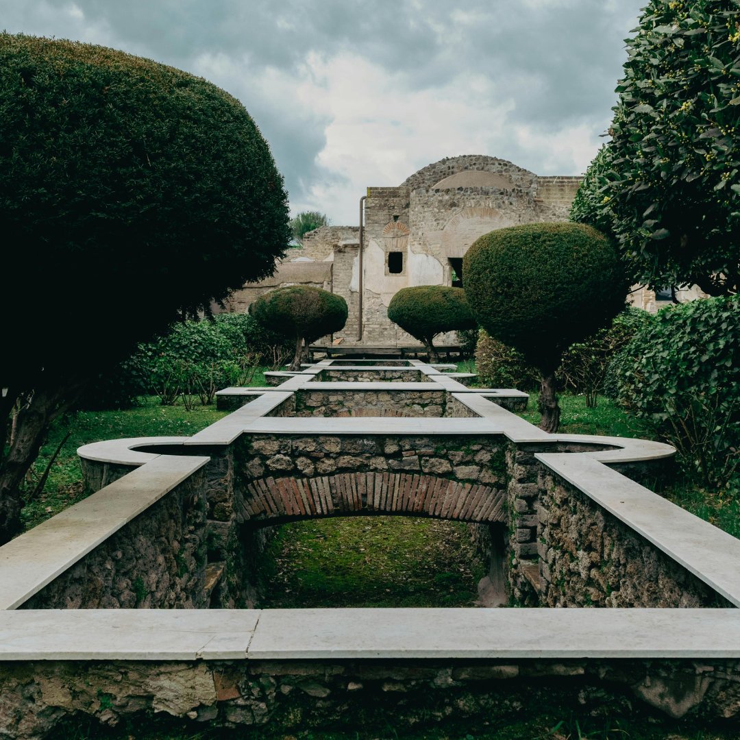 The formal sunken garden and arched portico of a luxury villa at the Pompeii site