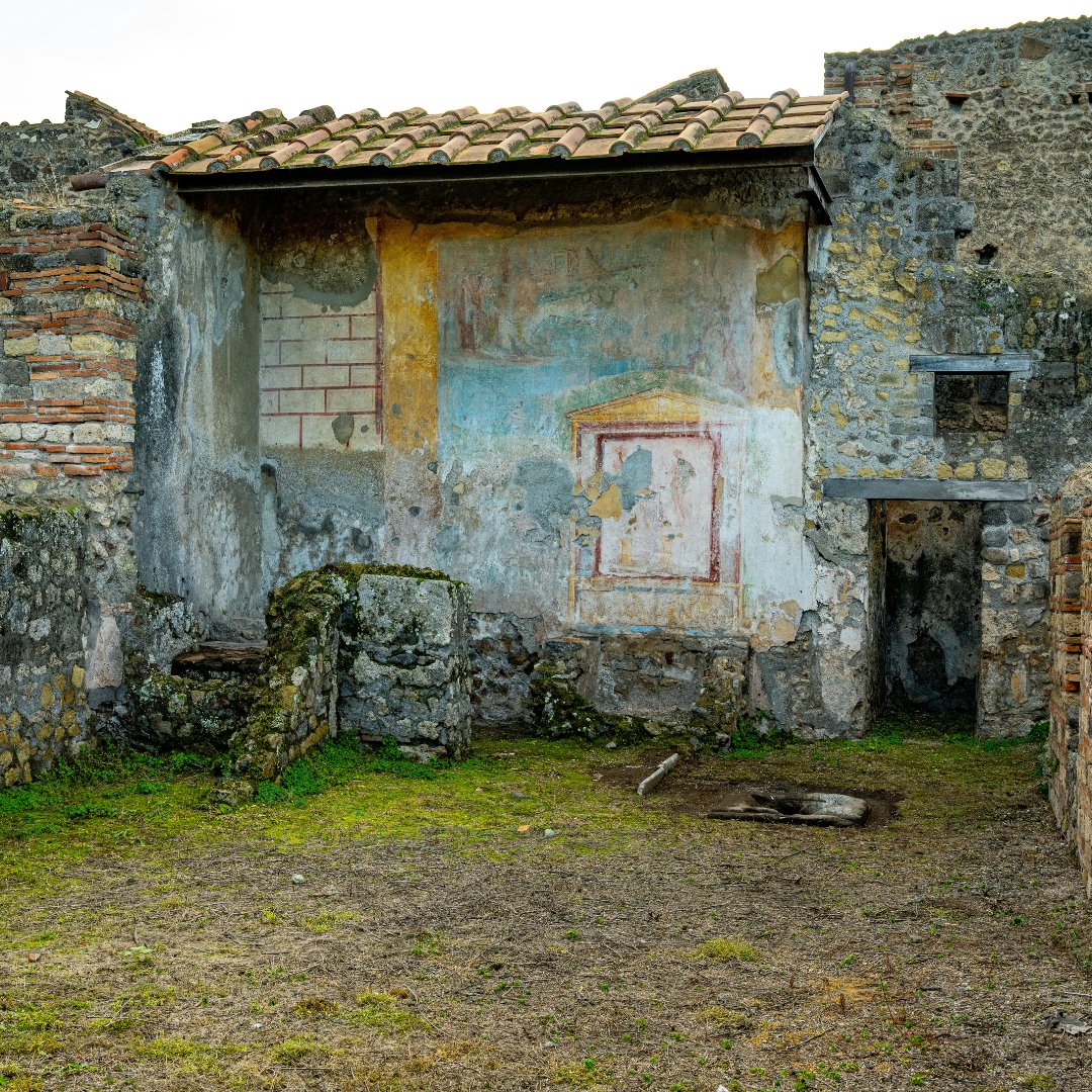 The interior of a Pompeian house with original painted shrine and tiled roof preserved