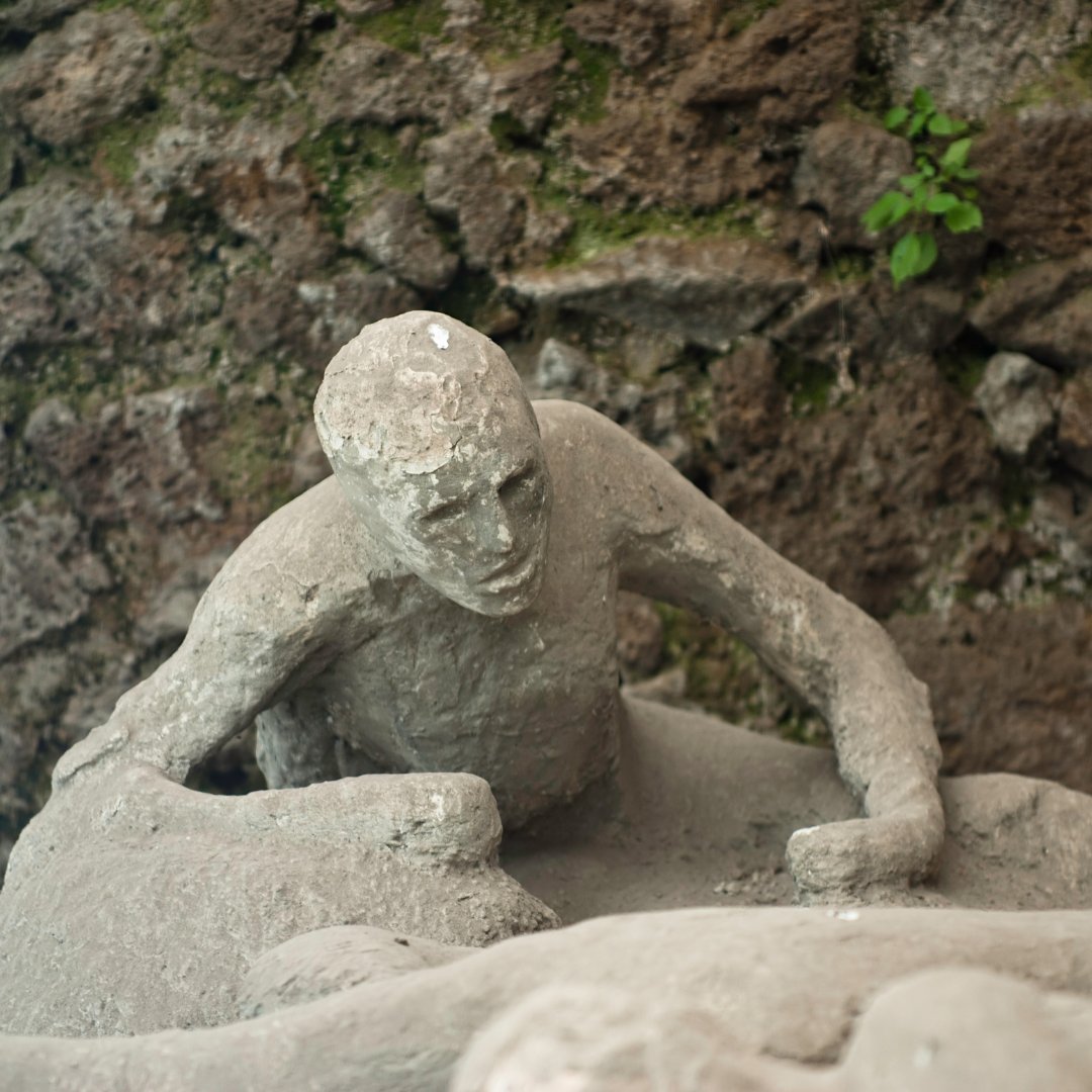 Plaster cast of a Pompeii victim crouched in the ash, on display at the archaeological site